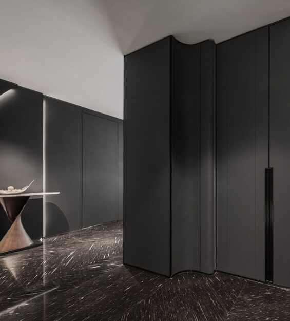 Dark wall paneled foyer with ambient lights design complimented with luxury furniture and stone decor elements