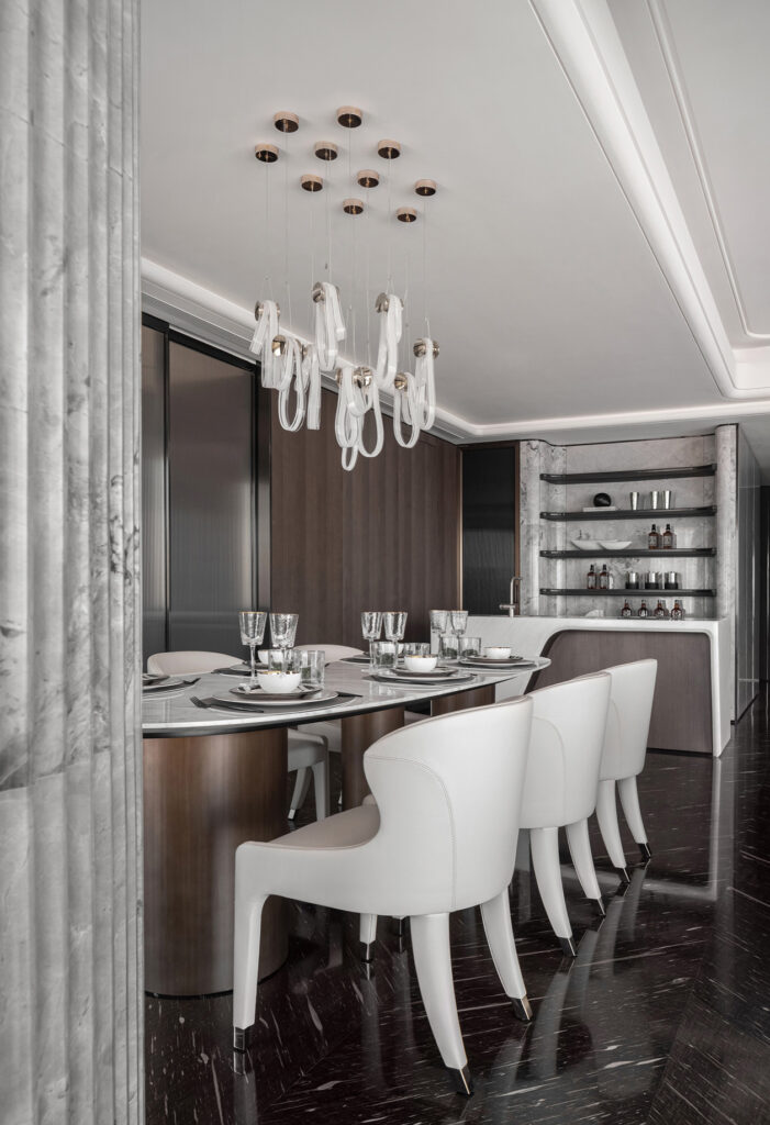 Modern bar & dining design with dark wood cabinetry, marble backsplash, island bar with curved elements. designer dining chair & dining table complimented with luxury bar